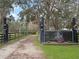 Private gated horse farm entrance with a wooden fence and landscaping creating a welcoming and secure approach at 1715 Fern Park Dr, Port Orange, FL 32128