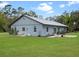 Charming home with a metal roof, well-manicured lawn, and small patio areas, blending comfort and style at 1715 Fern Park Dr, Port Orange, FL 32128