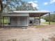 Exterior of a metal building featuring roll up doors and an adjacent covered area at 1715 Fern Park Dr, Port Orange, FL 32128