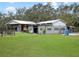 Exterior of a metal building on a large, grassy lot with an adjacent paddock at 1715 Fern Park Dr, Port Orange, FL 32128
