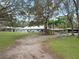 Large property featuring a home, guest house, carport and mature trees over a manicured green lawn at 1715 Fern Park Dr, Port Orange, FL 32128
