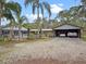 Exterior of a ranch home with mature landscaping, a metal roof, and an attached garage at 1715 Fern Park Dr, Port Orange, FL 32128