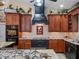 Charming kitchen featuring custom cabinetry, granite countertops, and decorative accents above the range hood at 1715 Fern Park Dr, Port Orange, FL 32128