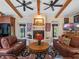 Cozy living room featuring a fireplace, exposed wood beams, and a comfortable seating arrangement at 1715 Fern Park Dr, Port Orange, FL 32128