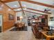 Spacious living area with wood-paneled wall, beamed ceilings, and seamless flow to the dining and kitchen at 1715 Fern Park Dr, Port Orange, FL 32128