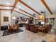 Open-concept living space with vaulted ceilings, exposed wood beams, tile floors, and a cozy fireplace at 1715 Fern Park Dr, Port Orange, FL 32128