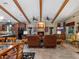 Inviting living room with a stone fireplace and wooden beam ceiling features a seamless flow to the kitchen area at 1715 Fern Park Dr, Port Orange, FL 32128