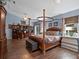 Spacious main bedroom with a four-poster bed, wood floors, and built-in shelving at 1715 Fern Park Dr, Port Orange, FL 32128