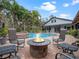 Resort-style pool and patio area with a fire pit, lounge chairs, and tropical landscaping at 1715 Fern Park Dr, Port Orange, FL 32128