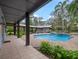 Covered patio by the pool with lounge area and garden, perfect for entertaining at 1715 Fern Park Dr, Port Orange, FL 32128