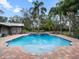 Beautiful backyard pool with a spa, water features, and lush landscaping creating a private oasis at 1715 Fern Park Dr, Port Orange, FL 32128