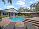 Resort-style pool with brick patio, hot tub, and lush landscaping surrounding the backyard oasis at 1715 Fern Park Dr, Port Orange, FL 32128