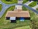 Aerial view of a well-maintained property featuring an extended covered patio, backyard, and long driveway in a quiet neighborhood at 1818 Enterprise Ave # B, New Smyrna Beach, FL 32168