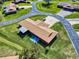 Aerial view highlighting a cozy home with an extended patio, long driveway, and well-maintained landscaping in a serene neighborhood at 1818 Enterprise Ave # B, New Smyrna Beach, FL 32168