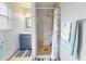 Well-lit bathroom with a tiled shower, modern vanity, and beach themed decor at 1818 Enterprise Ave # B, New Smyrna Beach, FL 32168