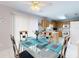 Bright dining area flowing into the kitchen with tile flooring, a glass-top table, and sliding glass doors at 1818 Enterprise Ave # B, New Smyrna Beach, FL 32168