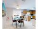 Dining area leading to the kitchen, featuring a table with glass top and ceiling fan at 1818 Enterprise Ave # B, New Smyrna Beach, FL 32168