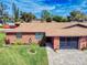 Charming brick duplex with a well-kept lawn, mature landscaping, and cozy curb appeal, offering comfortable living at 1818 Enterprise Ave # B, New Smyrna Beach, FL 32168