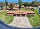 Aerial view of brick duplex with manicured lawn, mature landscaping and concrete driveway at 1818 Enterprise Ave # B, New Smyrna Beach, FL 32168