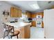 Well-lit kitchen offering a breakfast bar, white appliances, plenty of counter space and wood cabinets at 1818 Enterprise Ave # B, New Smyrna Beach, FL 32168