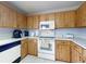 Kitchen featuring wood cabinets, white countertops, and appliances at 1818 Enterprise Ave # B, New Smyrna Beach, FL 32168
