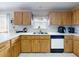 Kitchen showcasing light wood cabinetry, white countertops, stainless sink, and a window with valance at 1818 Enterprise Ave # B, New Smyrna Beach, FL 32168
