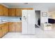 Bright, tile-floored kitchen with wood cabinets and a modern, side-by-side refrigerator at 1818 Enterprise Ave # B, New Smyrna Beach, FL 32168