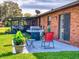 Charming patio with outdoor seating, a grill, lush lawn, and exterior view of the home at 1818 Enterprise Ave # B, New Smyrna Beach, FL 32168