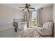 A charming Bedroom features a gray crib, a rocking chair, stylish flooring, and a bright window at 1880 1St Ave, Deland, FL 32724
