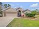 Charming single-story home featuring a well-maintained lawn and a two-car garage at 1880 1St Ave, Deland, FL 32724