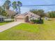 Beautifully landscaped single-story home with a large front yard, driveway, and two-car garage at 1880 1St Ave, Deland, FL 32724