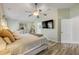 A light-filled main bedroom showcases stylish wood flooring, a ceiling fan, and a large wall-mounted television at 1880 1St Ave, Deland, FL 32724
