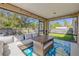 Cozy screened-in porch, furnished with a table and sectional seating, overlooking the fenced yard at 1880 1St Ave, Deland, FL 32724