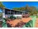 Home's backyard featuring a cozy patio, seating, and a screened-in porch at 191 Howes St, Oak Hill, FL 32759