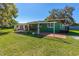 Exterior of green house with a grassy lawn and trees at 191 Howes St, Oak Hill, FL 32759