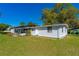 Backyard showcasing the home's exterior, lawn, and surrounding greenery at 191 Howes St, Oak Hill, FL 32759