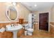 Bathroom featuring a pedestal sink, a toilet, tiled floors, and unique doors at 191 Howes St, Oak Hill, FL 32759