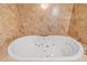 Close up of a white soaking tub with jets surrounded by tile at 191 Howes St, Oak Hill, FL 32759
