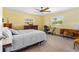 Sunny bedroom with a ceiling fan, carpeted floor, and natural light from the windows at 191 Howes St, Oak Hill, FL 32759