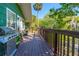 Exterior shot of a wooden deck with a grill, chairs, and lovely landscaping at 191 Howes St, Oak Hill, FL 32759