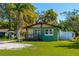 Green home with a front porch, a gravel driveway, and a grassy lawn at 191 Howes St, Oak Hill, FL 32759