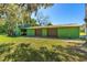 A detached green painted garage with two bays and an upper level on a lot with grass at 191 Howes St, Oak Hill, FL 32759