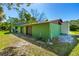 Large detached garage with two bays, green exterior paint, and mature trees on the lot at 191 Howes St, Oak Hill, FL 32759
