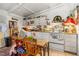 A kitchen featuring dated appliances, table and chairs, and cluttered countertops at 191 Howes St, Oak Hill, FL 32759