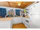 Bright kitchen with white cabinets, laminate counters and shelving for pantry storage at 191 Howes St, Oak Hill, FL 32759