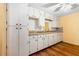 Kitchen with white cabinets, wood floor, and tile backsplash at 191 Howes St, Oak Hill, FL 32759