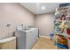 Neat laundry room with modern washer, dryer, and ample storage shelving at 191 Howes St, Oak Hill, FL 32759