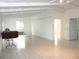 Spacious room with tile floor and white walls and ceiling with exposed beams. Multiple doors to other rooms at 191 Howes St, Oak Hill, FL 32759