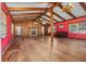 Large living room with red walls, wood floors, fireplace, and exposed ceiling beams at 191 Howes St, Oak Hill, FL 32759