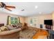 A cozy living room with hardwood floors, a ceiling fan, and natural light from the windows at 191 Howes St, Oak Hill, FL 32759